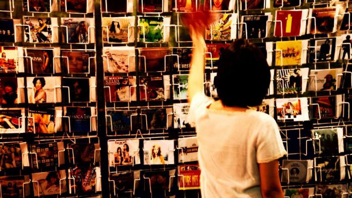 person-wearing-white-shirt-holding-vinyl-albums-851177 (1)