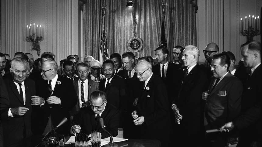 Martin Luther King assiste ao presidente Lyndon Johnson assinar a Lei dos Direitos Civis, em 1964